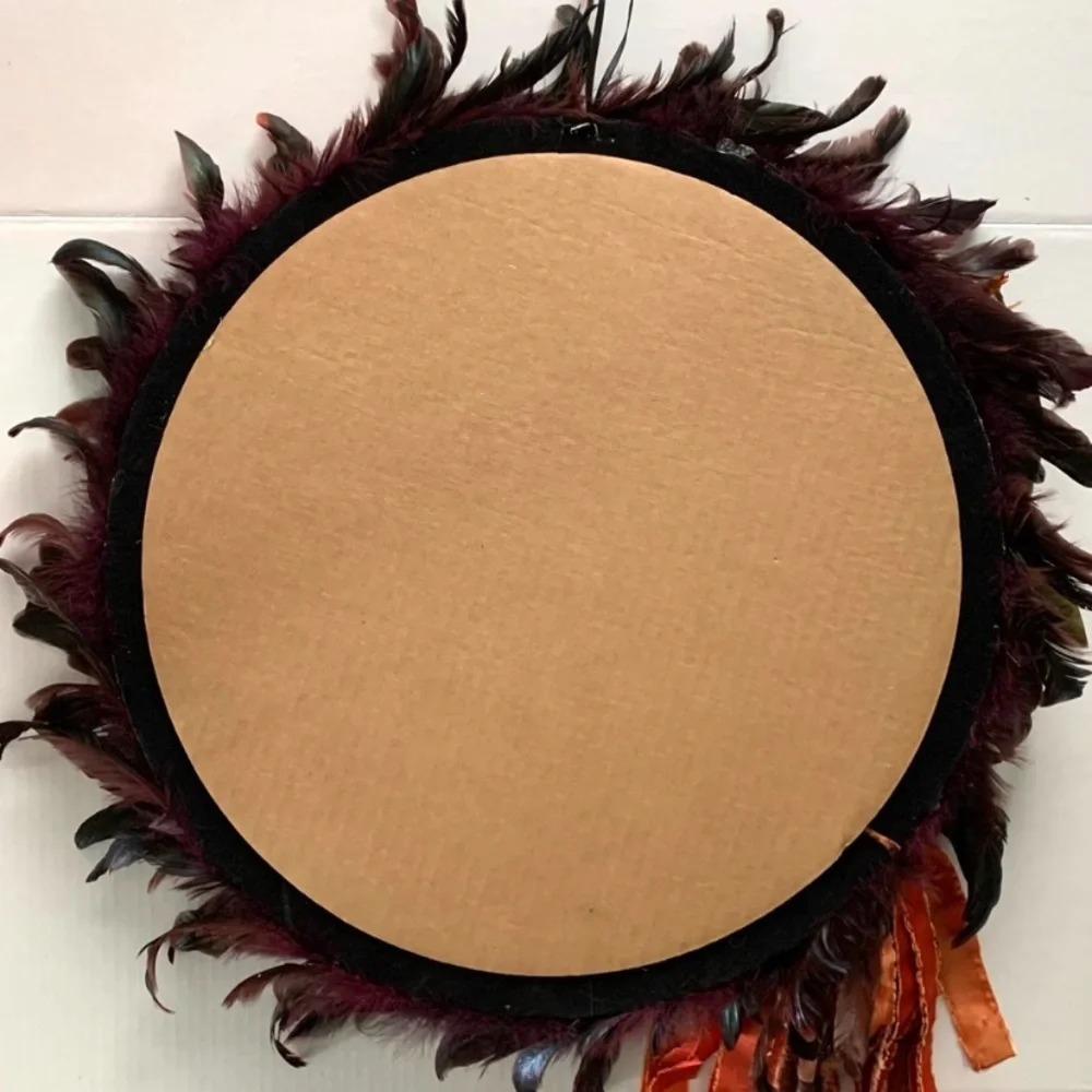 Dark red and black feather wreath with fall floral and a crowned crow center